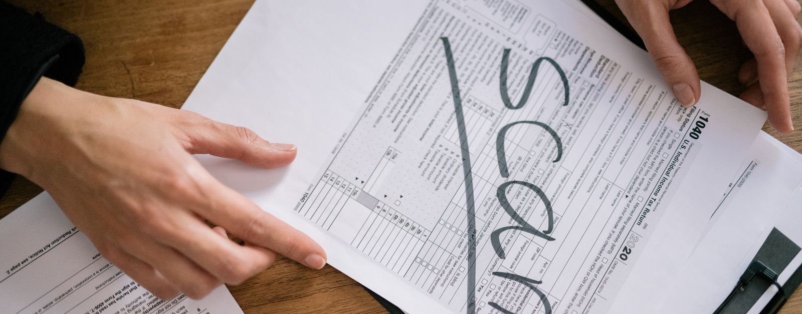An older New Mexico couple reviewing a tax return and financial paperwork at a home desk while planning for Medicare income-related premiums
